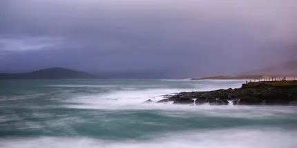 Coastal scene at Bagh Steinigidh where ribbons of water fall from the rock pools into the sea.  A soft purple/pink sky creates dreamlike image.