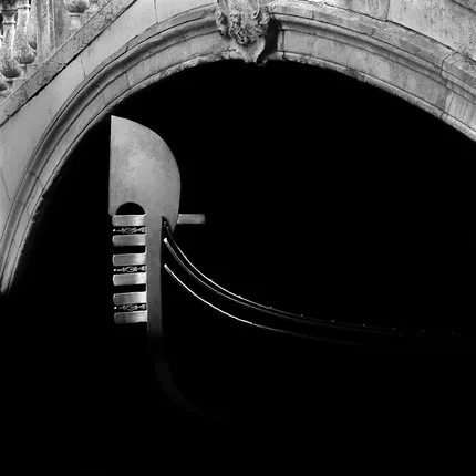 The Ferro, a distinctive ornament of the Venetian gondola emerges from the dark.  An atmosphere of mystery is  created.