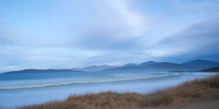 Scarista Beach during the blue hour with a long soft wave sweeping towards the shore.