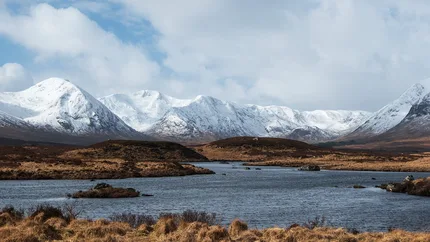 Snow covered mountains are the backdrop to Loch Ba on Rannoch Moor.
