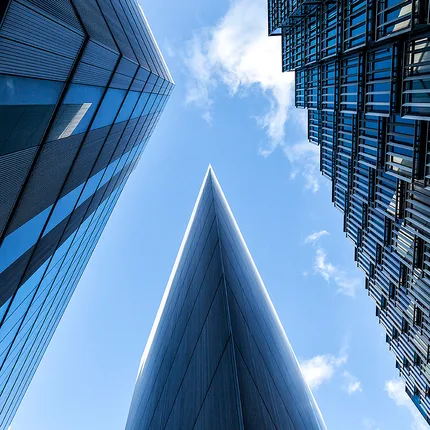 Looking up between tall buildings at More, London