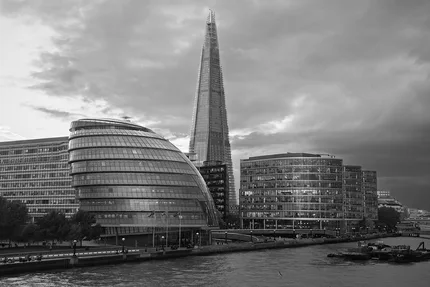 A black and white photograph of he former City Hall in London with the Shard and offices in the background.