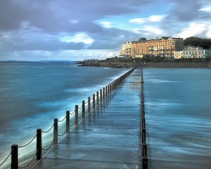 A slow shutter speed over the water of the sea wall with beautiful natural light catching the surface.