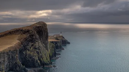 A dramatic seascape  over Neist Point in Western Skye where dark clouds gather.  Shafts of light fall across the sea.