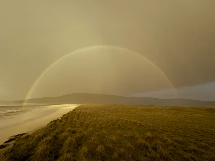 A rainbow arches above Seilebost Beach before a storm approaches.
